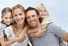 A man and woman holding two children in their arms.